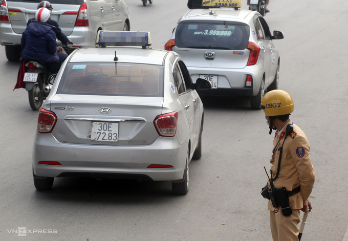 Xe taxi dùng kẹp giấy che biển số, khi thấy cảnh sát, tài xế vội tăng ga bỏ chạy. Ảnh: Bá Đô