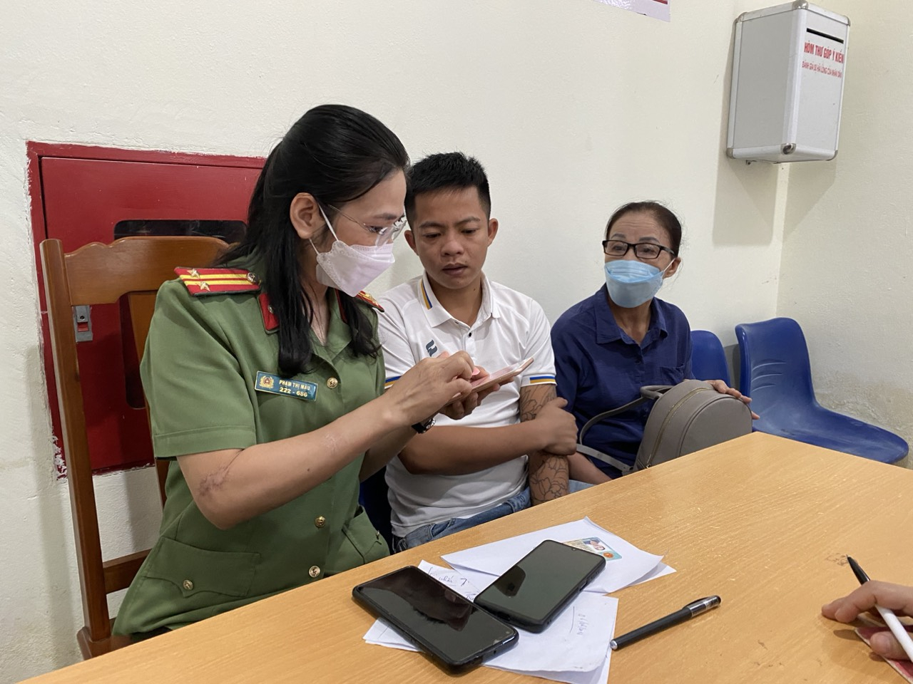 Cán bộ Phòng Quản lý xuất nhập cảnh hướng dẫn người dân nộp hồ sơ trực tuyến qua Cổng dịch vụ Công Quốc gia. (Ảnh: CATH)