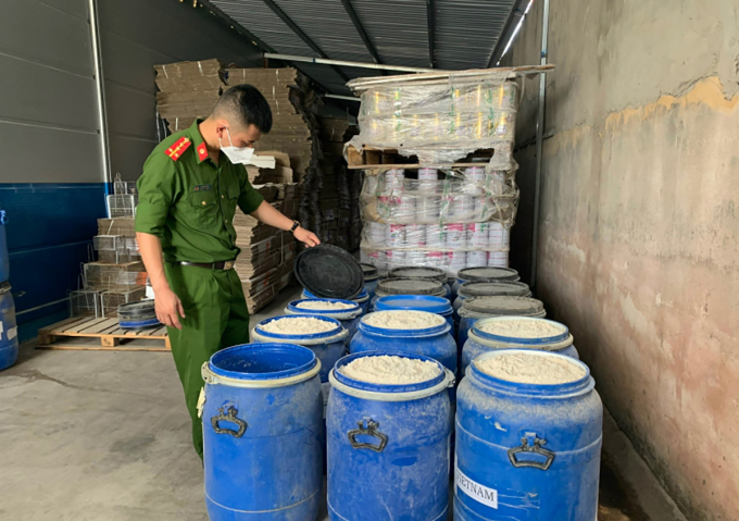 Cảnh s&aacute;t kiểm tra c&aacute;c l&ocirc; sữa bột đựng trong th&ugrave;ng của C&ocirc;ng ty Cổ phần sữa H&agrave; Lan. Ảnh: C&ocirc;ng an cung cấp
