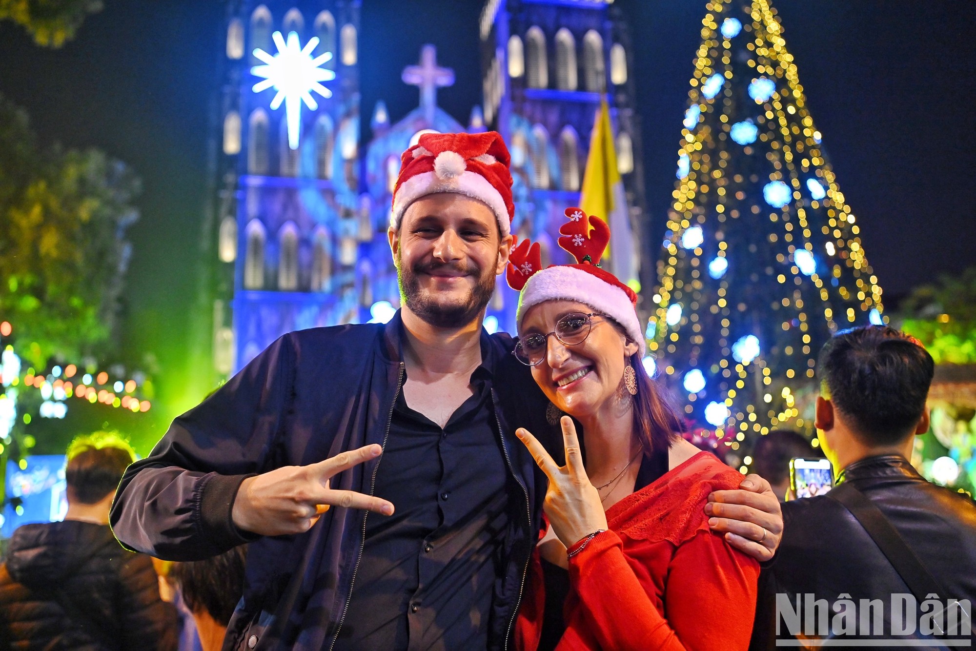 Một cặp đôi người nước ngoài tận hưởng không khí Giáng sinh tại Nhà thờ Lớn. (Ảnh: THÀNH ĐẠT)