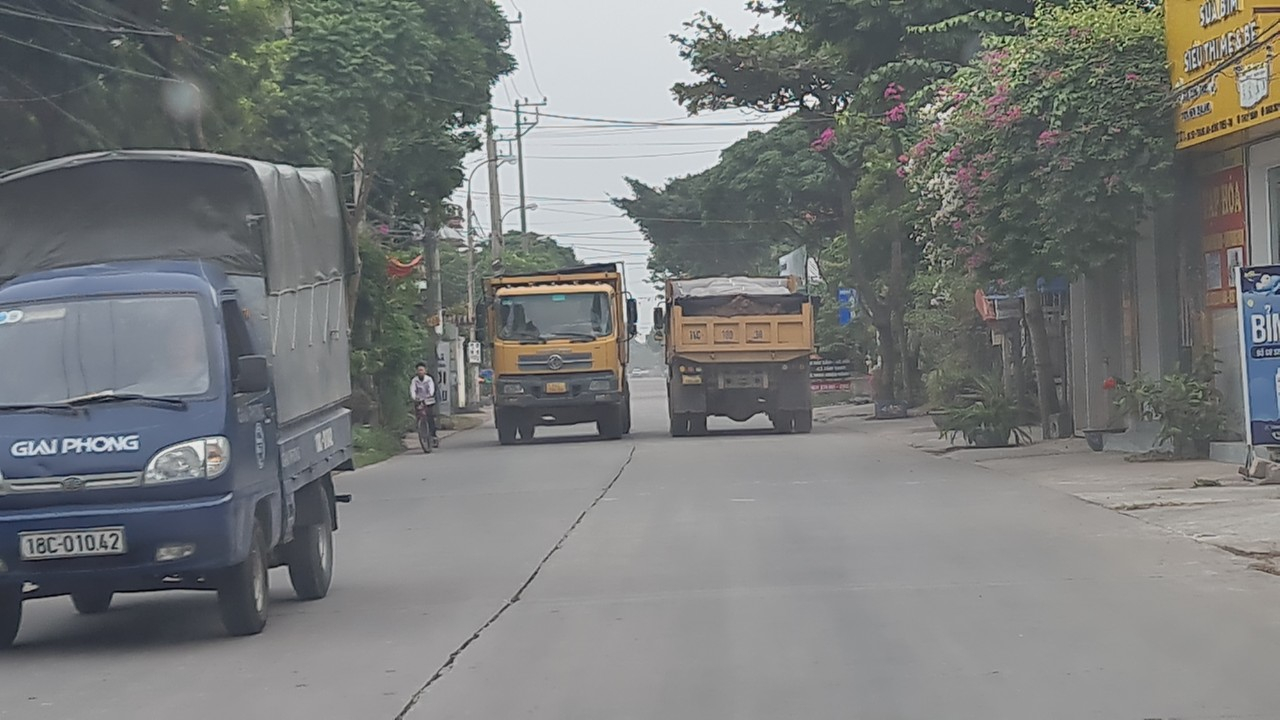 Nhiều xe tải chạy tung hoành trong khu đông dân cư khiến các em học sinh đi nép vào bên đường.