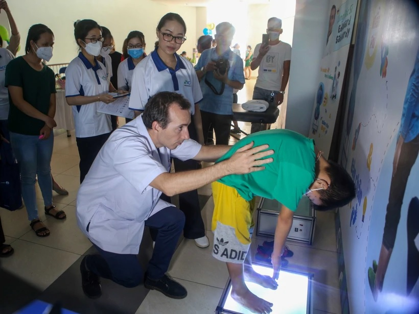 Khám tầm soát bệnh vẹo cột sống cho trẻ em. (Ảnh: Trần Lê Lâm/TTXVN)